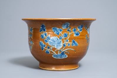 Un cachepot en porcelaine de Chine &agrave; d&eacute;cor en bleu et blanc sur fond brun, 19&egrave;me