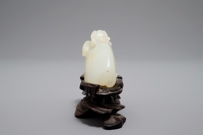 A Chinese jade carving of a ram on wooden base, 19th C.