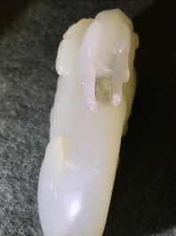 A Chinese jade carving of a ram on wooden base, 19th C.