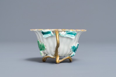 A Chinese famille rose lotus-shaped relief-decorated cup and saucer, Yongzheng