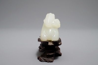 A Chinese jade carving of a ram on wooden base, 19th C.