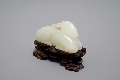 A Chinese jade carving of a ram on wooden base, 19th C.