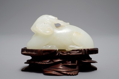 A Chinese jade carving of a ram on wooden base, 19th C.