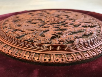 A round Chinese cinnabar lacquer plaque with two dragons, 18th C.