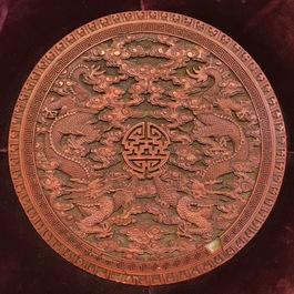 A round Chinese cinnabar lacquer plaque with two dragons, 18th C.