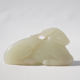 A Chinese jade carving of a ram on wooden base, 19th C.