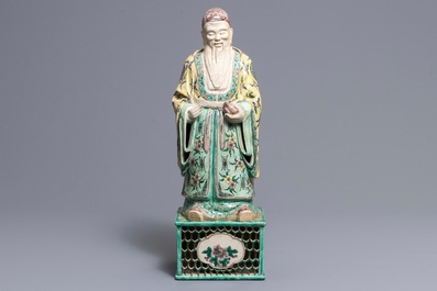 A large Chinese verte biscuit figure of an immortal on reticulated stand, Kangxi