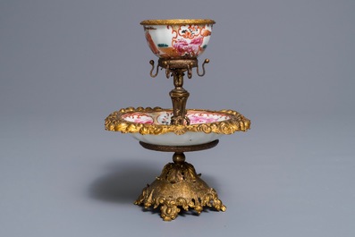 Une tasse et soucoupe en porcelaine de Chine famille rose &agrave; monture en m&eacute;tal dor&eacute;, Qianlong et 19&egrave;me