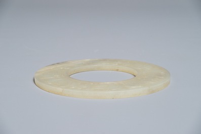 A Chinese pale celadon jade bi disc, Ming or earlier