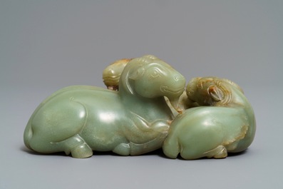 A Chinese pale celadon and russet jade 'three rams' group on carved wooden stand, 18/19th C.