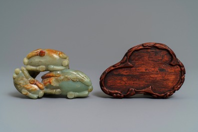 A Chinese pale celadon and russet jade 'three rams' group on carved wooden stand, 18/19th C.