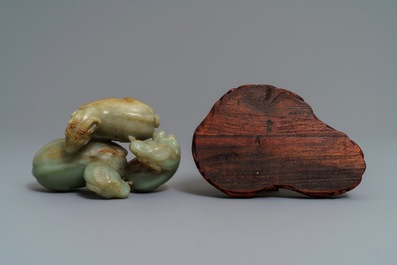 A Chinese pale celadon and russet jade 'three rams' group on carved wooden stand, 18/19th C.