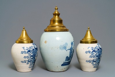 Three Dutch Delft blue and white tobacco jars with brass covers, 18th C.