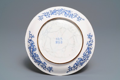 Une assiette en &eacute;maux de Canton &agrave; d&eacute;cor de figures dans un jardin, marque et &eacute;poque de Qianlong