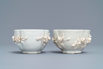 A pair of Chinese blue and white 'soft paste' relief-decorated cups and saucers, Qianlong