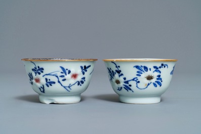 A pair of Chinese blue, white and underglaze red cups and saucers, Kangxi