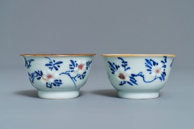 A pair of Chinese blue, white and underglaze red cups and saucers, Kangxi