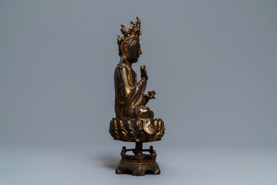 Een Chinese gelakt en verguld bronzen figuur van Guanyin op een lotustroon, Ming