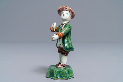 A polychrome Dutch Delft figure of a boy with a hat, 18th C.