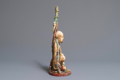 A polychrome Chinese ivory group of a sage with a tiger, 19/20th C.