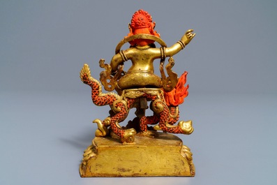 A Sino-Tibetan painted gilt bronze figure of Jambhala on a dragon, 19/20th C.