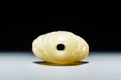 A reticulated Chinese celadon jade pendant and a lotus leaf with birds, 19/20th C.