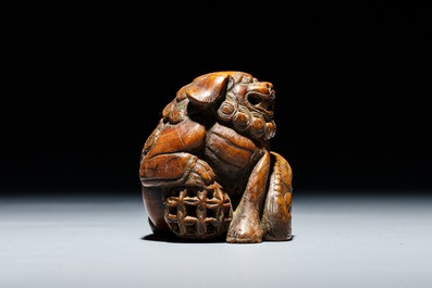 A Japanese carved wood netsuke of a shishi with cub, Edo, 18/19th C.