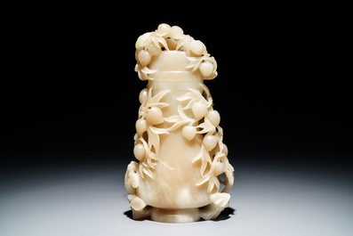 A Chinese pale brownish white jade vase with monkeys in a peach tree, 19th C.