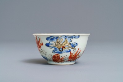 A Chinese iron red, grisaille, gilt and overglaze blue 'carps and crane' cup and saucer, Yongzheng