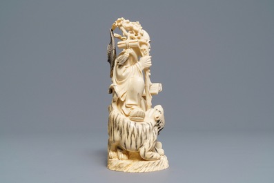 A Chinese ivory group of a sage with a tiger, 19/20th C.