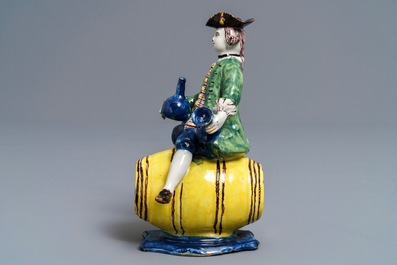A polychrome Dutch Delft figure of a man on a barrel, 18th C.