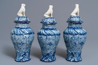Three Dutch Delft blue and white dog-topped vases and covers, 18th C.