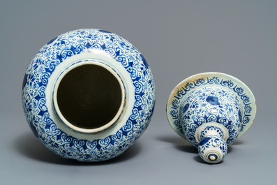 A Dutch Delft blue and white three-piece garniture with carved wooden candleholders, 18th C.