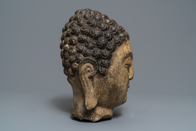 A Chinese carved stone head of Buddha with traces of gilding and polychromy, Ming