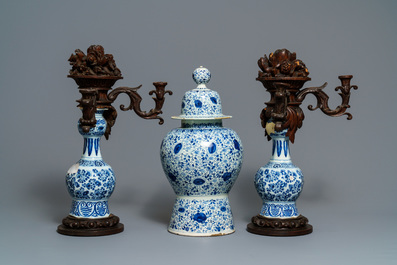 A Dutch Delft blue and white three-piece garniture with carved wooden candleholders, 18th C.