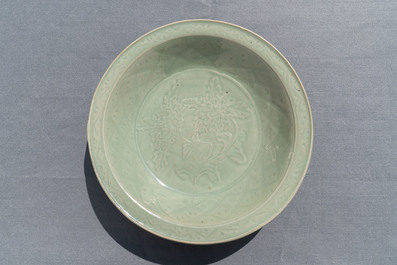 Een Chinese Longquan celadon schotel met onderglazuur pioenrozendecor, Ming