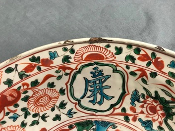 Een Chinese polychrome Swatow schotel met twee figuren in een landschap, Ming