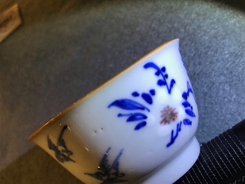 A pair of Chinese blue, white and underglaze red cups and saucers, Kangxi
