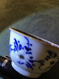 A pair of Chinese blue, white and underglaze red cups and saucers, Kangxi