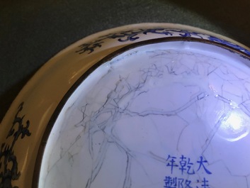 Une assiette en &eacute;maux de Canton &agrave; d&eacute;cor de figures dans un jardin, marque et &eacute;poque de Qianlong