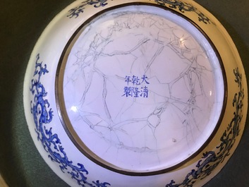 Une assiette en &eacute;maux de Canton &agrave; d&eacute;cor de figures dans un jardin, marque et &eacute;poque de Qianlong