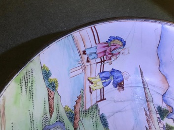 Une assiette en &eacute;maux de Canton &agrave; d&eacute;cor de figures dans un jardin, marque et &eacute;poque de Qianlong