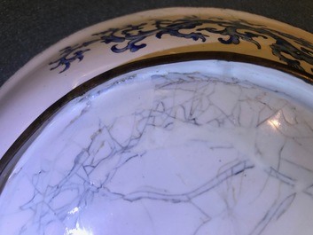 Une assiette en &eacute;maux de Canton &agrave; d&eacute;cor de figures dans un jardin, marque et &eacute;poque de Qianlong