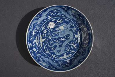 Une assiette en porcelaine de Chine bleu et blanc &agrave; d&eacute;cor invers&eacute; d'un dragon, marque et prob. &eacute;poque de Daoguang