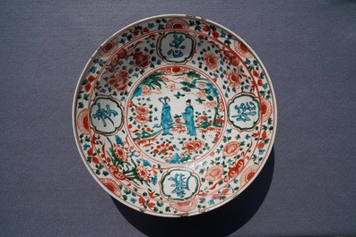 Een Chinese polychrome Swatow schotel met twee figuren in een landschap, Ming