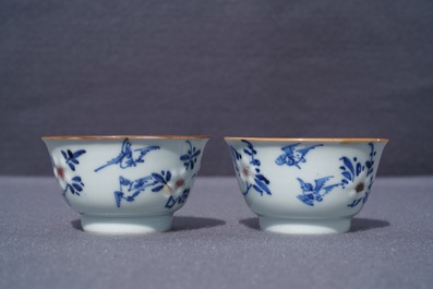 A pair of Chinese blue, white and underglaze red cups and saucers, Kangxi