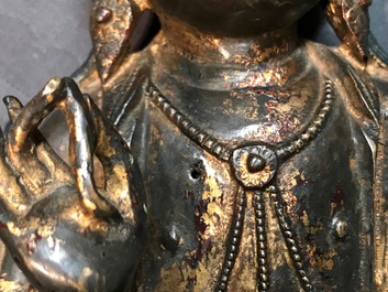Een Chinese gelakt en verguld bronzen figuur van Guanyin op een lotustroon, Ming