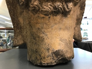 A Chinese carved stone head of Buddha with traces of gilding and polychromy, Ming