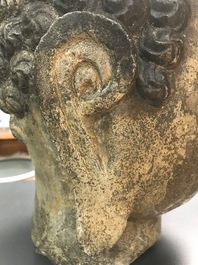 A Chinese carved stone head of Buddha with traces of gilding and polychromy, Ming