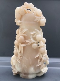 A Chinese pale brownish white jade vase with monkeys in a peach tree, 19th C.